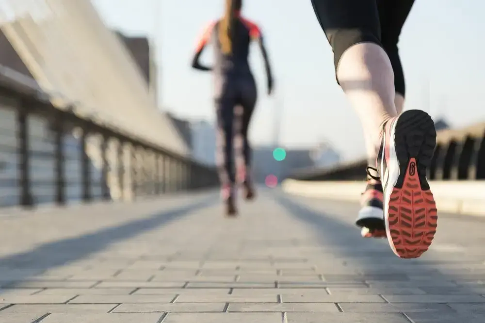 The image depicts two people running, highlighting the necessity and benefits of treating spider veins.