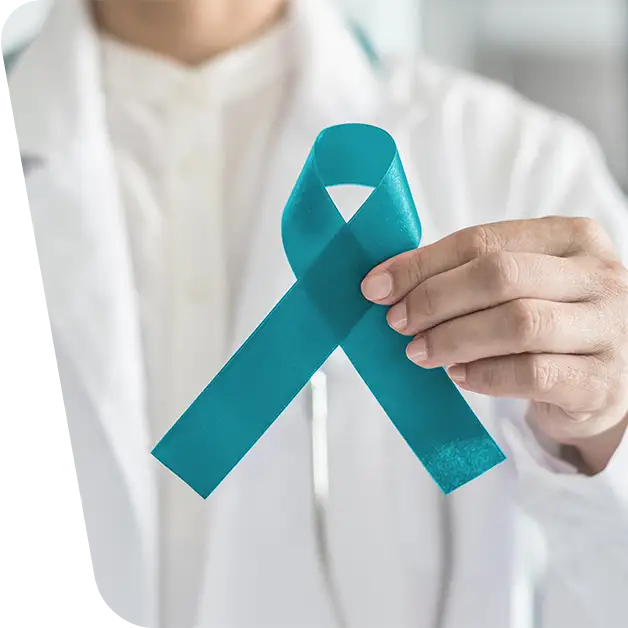 Imaginea surprinde o mână care ține o fundă albastru ciclam, simbol al luptei împotriva cancerului ovarian și susținere pentru pacienți. Aflați mai multe despre opțiunile de tratament și sprijinul disponibil în articolul nostru specializat.