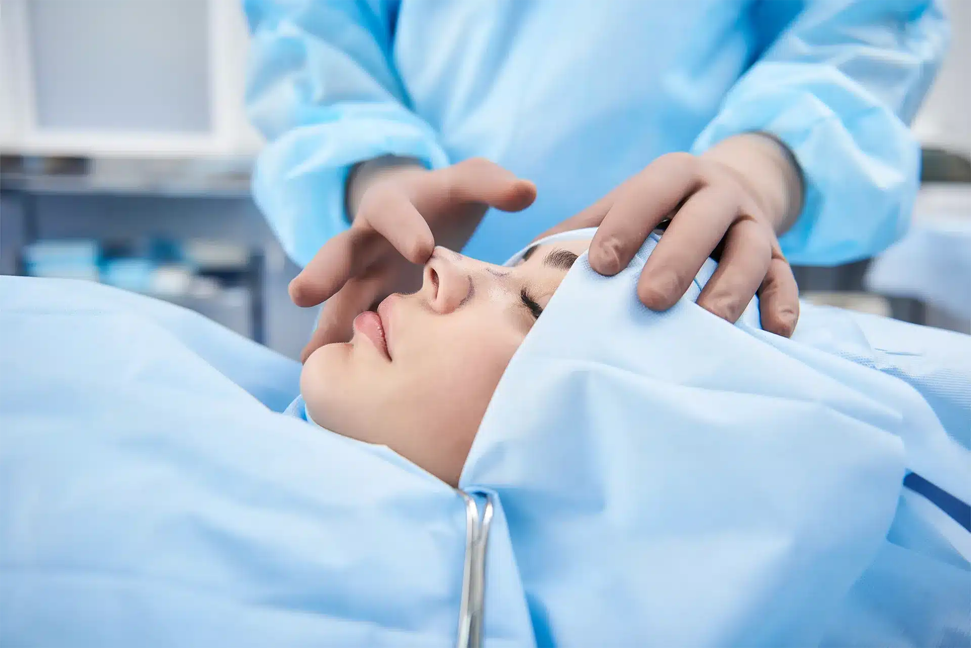 Medic care îi face rinoplastie unei doamne. Chirurgul palpează nasul unei paciente de sex feminin