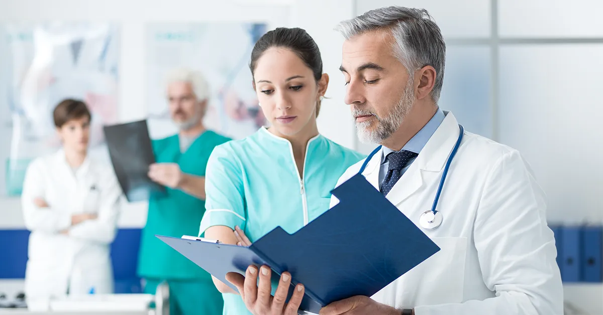Featured image for the about us page showing 2 doctors discussing a medical file